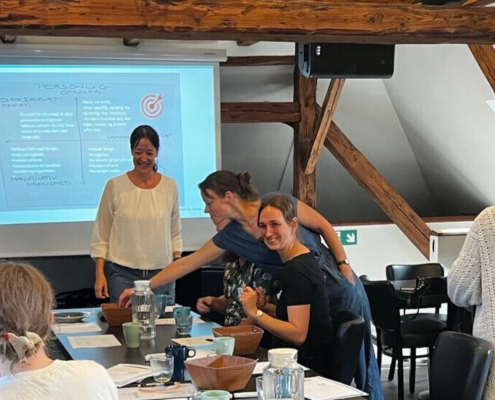 3️⃣ Billede: Smilende team, der taler åbent ved bord. Alt‑tekst: "Psykologisk tryghed og feedbackkultur som del af teamsamarbejde."